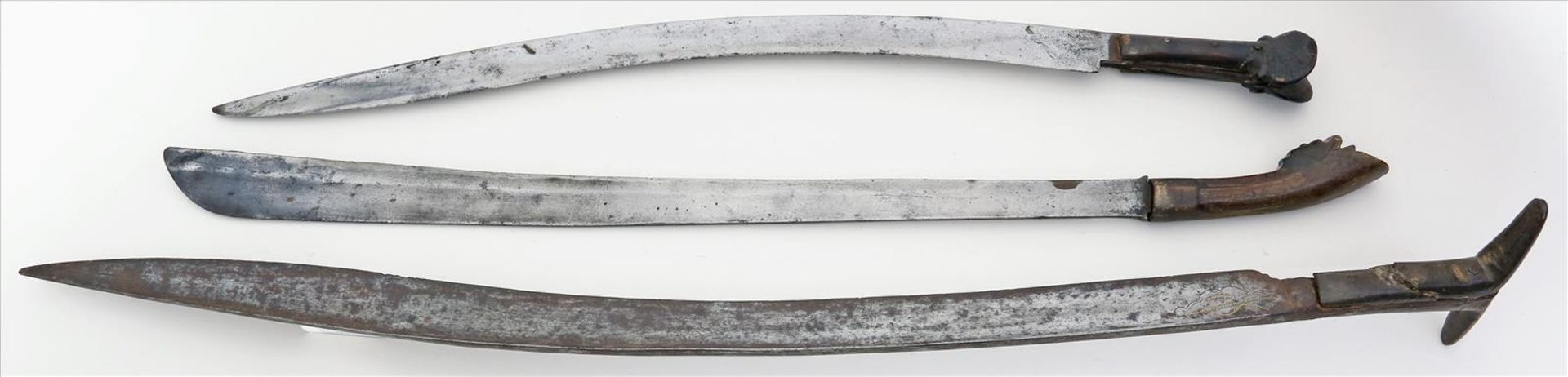 3 Schwerter aus Indonesien.Pedang und Yatagan. Eisenklingen. Geschnitzte Holzgriffe (besch.).