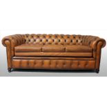 Chesterfield-Sofa.3-Sitzer. Braune Polsterung mit Steppung. Gebrauchsspuren. 20. Jh. 77x 216x 85
