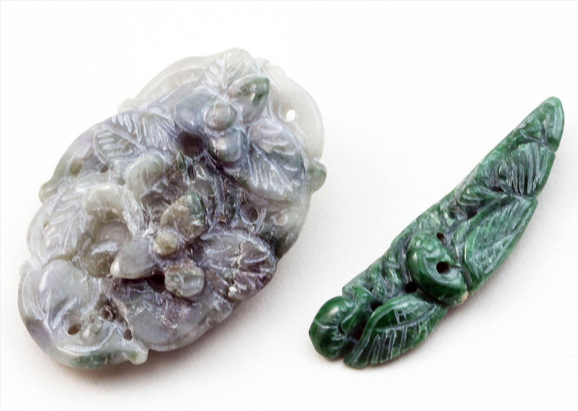 2 Jadegravuren.Verschiedene Farben und florale Darstellungen. L. 3,8 bzw. 4,2 cm.