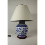 Porseleinen lampvoet met bloemdecor en stoffen kap, China 20e eeuw, h. 75 cm.