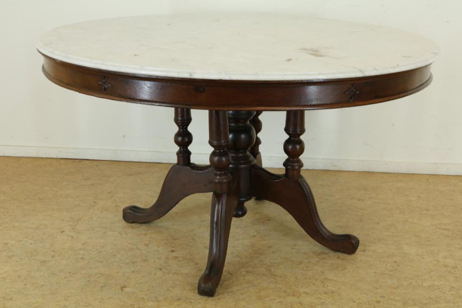 Teakhouten tafel met marmeren blad op gedraaide poten uitlopend in 4-sprant, h. 78, diam. 137 cm.
