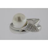 A white gold ring mounted with pearl and brillinat, 18kt. w. 5.5gr. size 17Een witgouden