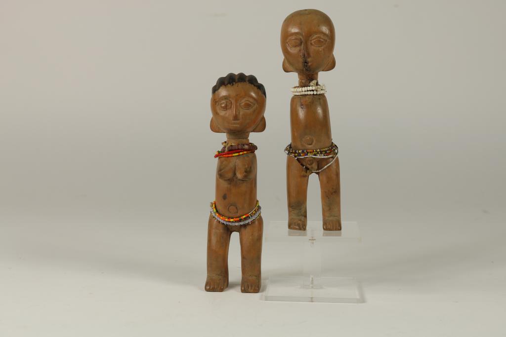 a pair of 2 wooden twindolls, Togo, Ewe, H. 17 cm.Stel blankhouten tweelingpopjes met glaskraaltjes,