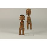 a pair of 2 wooden twindolls, Togo, Ewe, H. 17 cm.Stel blankhouten tweelingpopjes met glaskraaltjes,