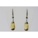 A pair of white gold drop earrings set with diamond and citrine, gross w. 8.4gr, length 4.5cm.Een