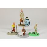 Lot of 5 Tintin figurines.Lot van 4 kunststof Kuifje sculptuurtjes en Kuifje in porseleinen vaas,