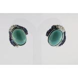 A set of white gold earrings set with an oval cabochon cut turquoise, baguette cur sapphires and