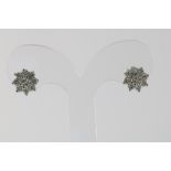 A pair of white gold earrings with diamond 18kt.Witgouden oorknoppen bezet met diamant