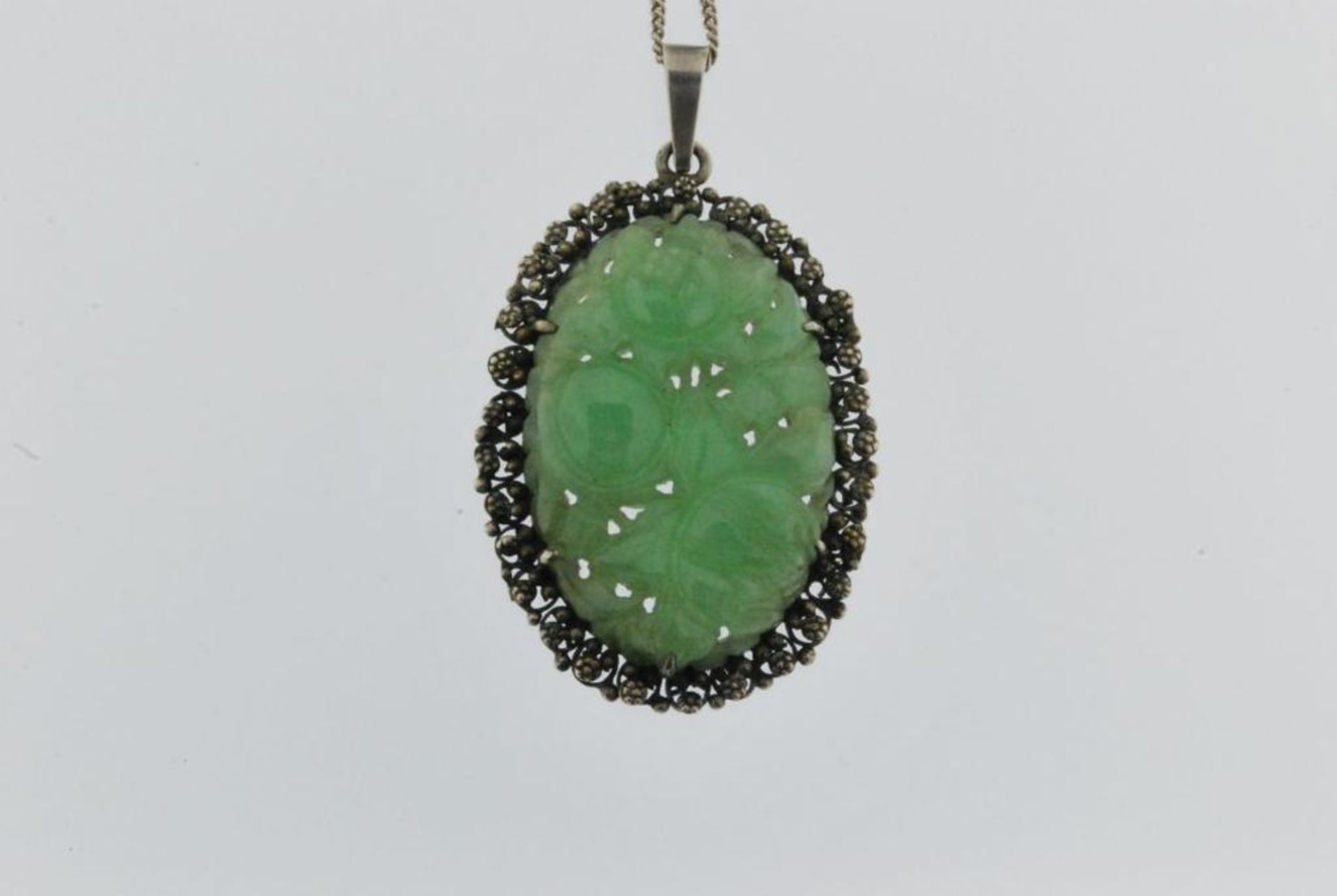 A floral cut jade pendant with silver mount and necklace, 835/000, gross w. 20gr, pendent length