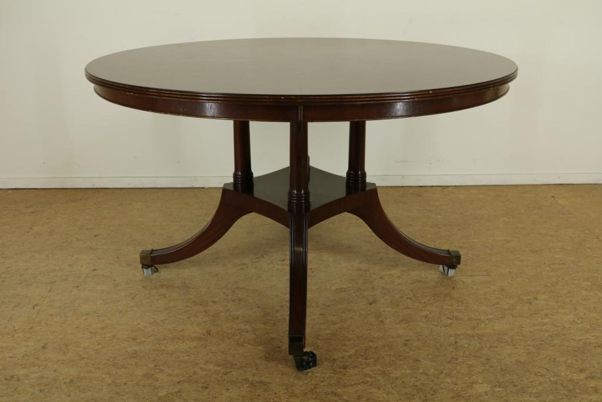 Mahonie Hepplewhite-stijl tafel op 4-sprant en koperen wielen, Engeland, h. 78, diam. 132 cm.