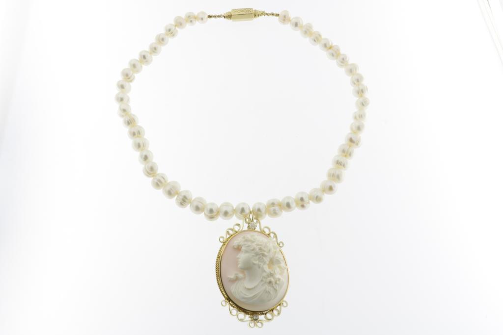 A cultivated pearl necklace with shell cameo in golden mount and golden lock, 585/000, gross w. 99.