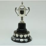 A wooden pedestal with silver and metal shield to commemorate football matches in the period 1928-