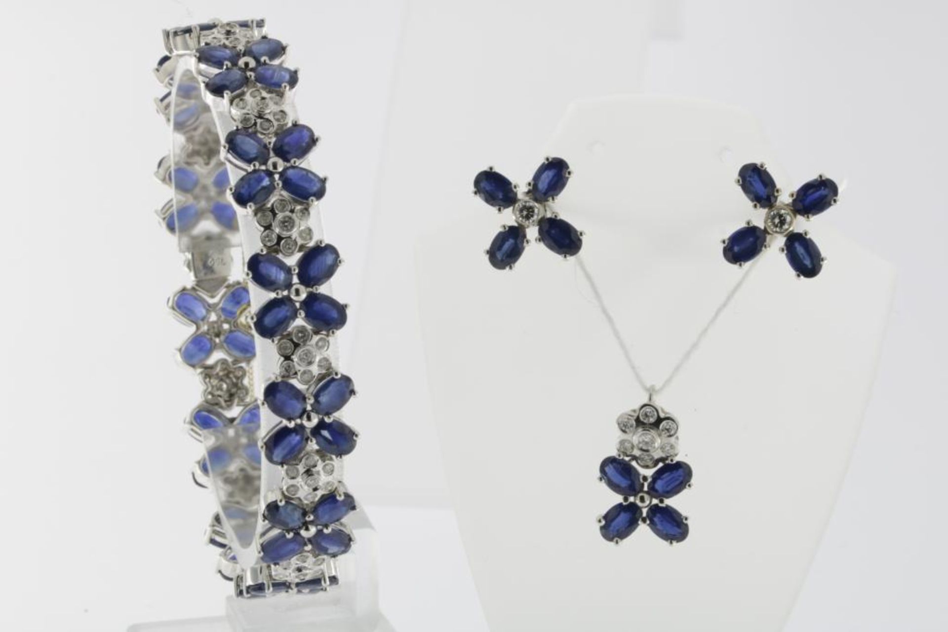 A white gold bracelet with matching earings and pendant, set with diamonds and sapphires, 750/000,