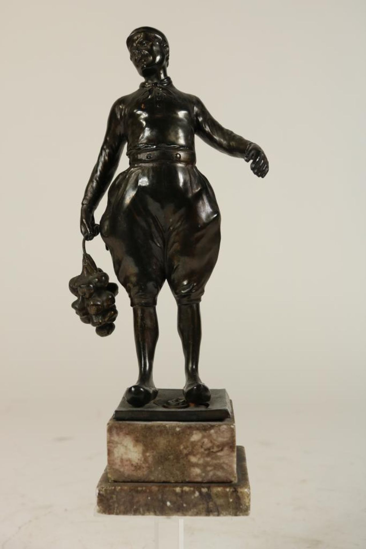 Bronzen sculptuur van boer met fruittros op marmeren voet, h. 26 cm.