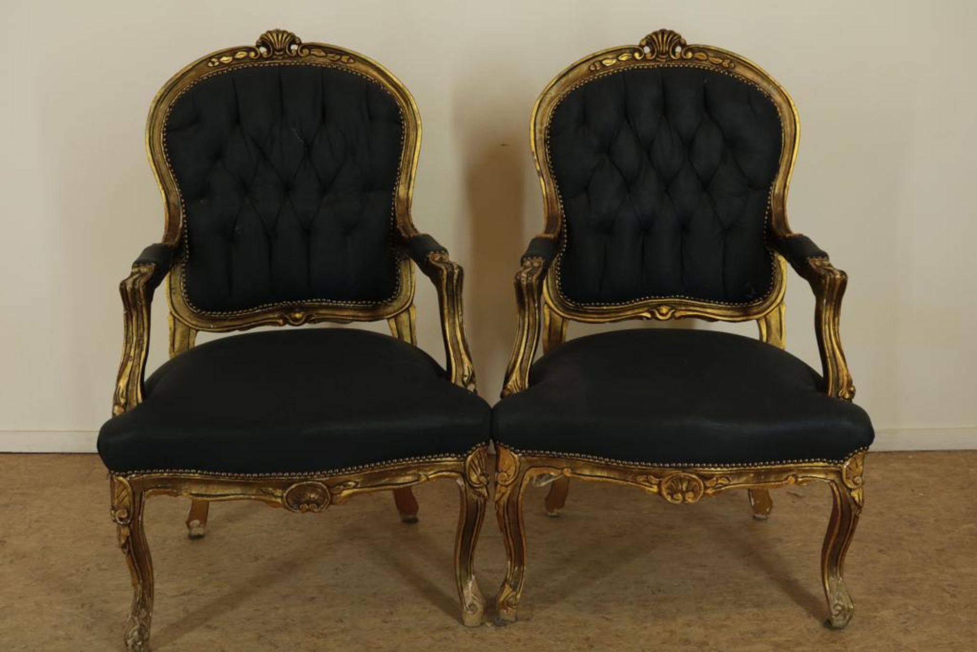 Stel goudlak Louis XV-stijl armstoelen met zwarte bekleding.