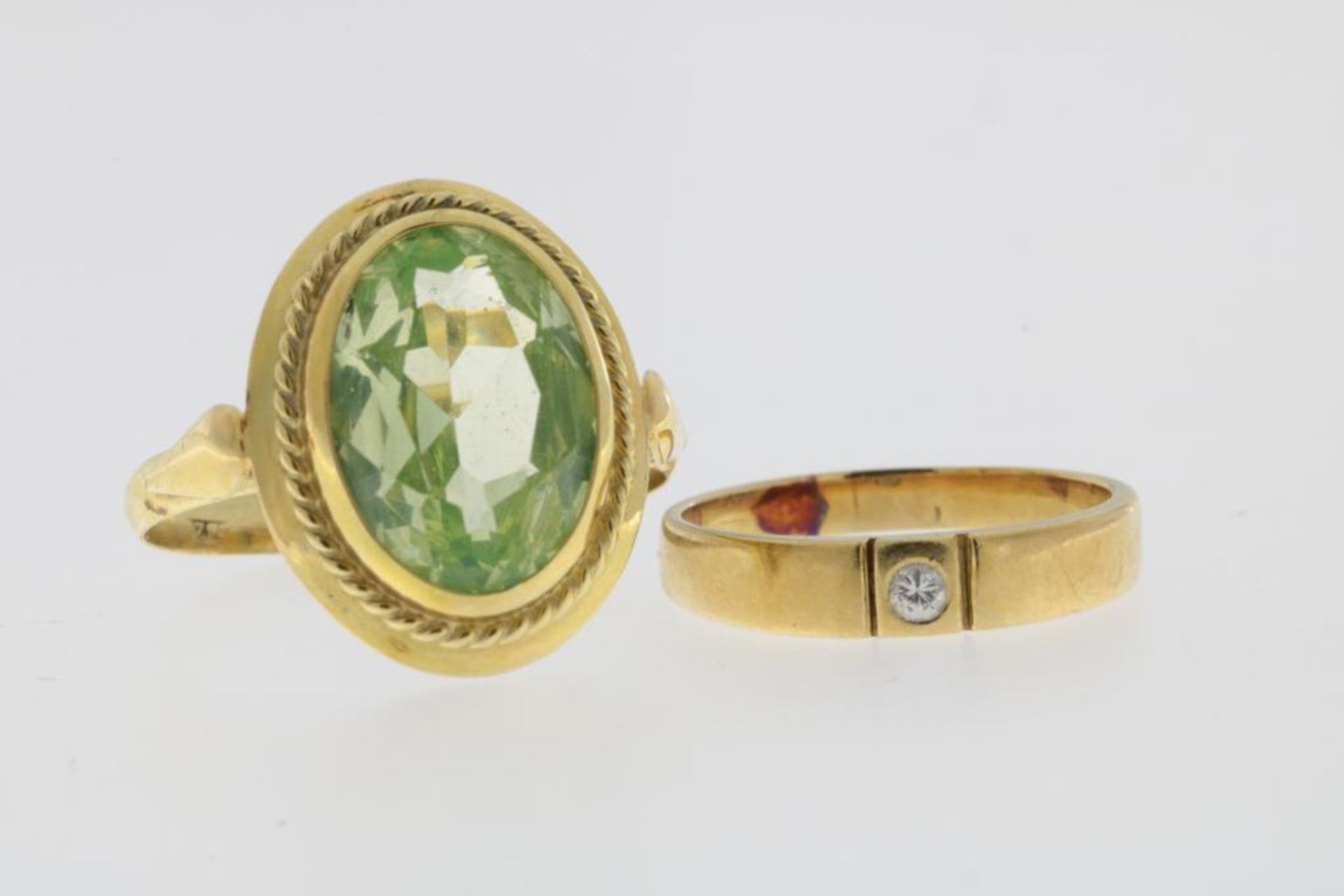 Twee geelgouden ringen bezet met groene paste en briljant geslepen diamant, 585/000, br.gew. 6,5 gr,