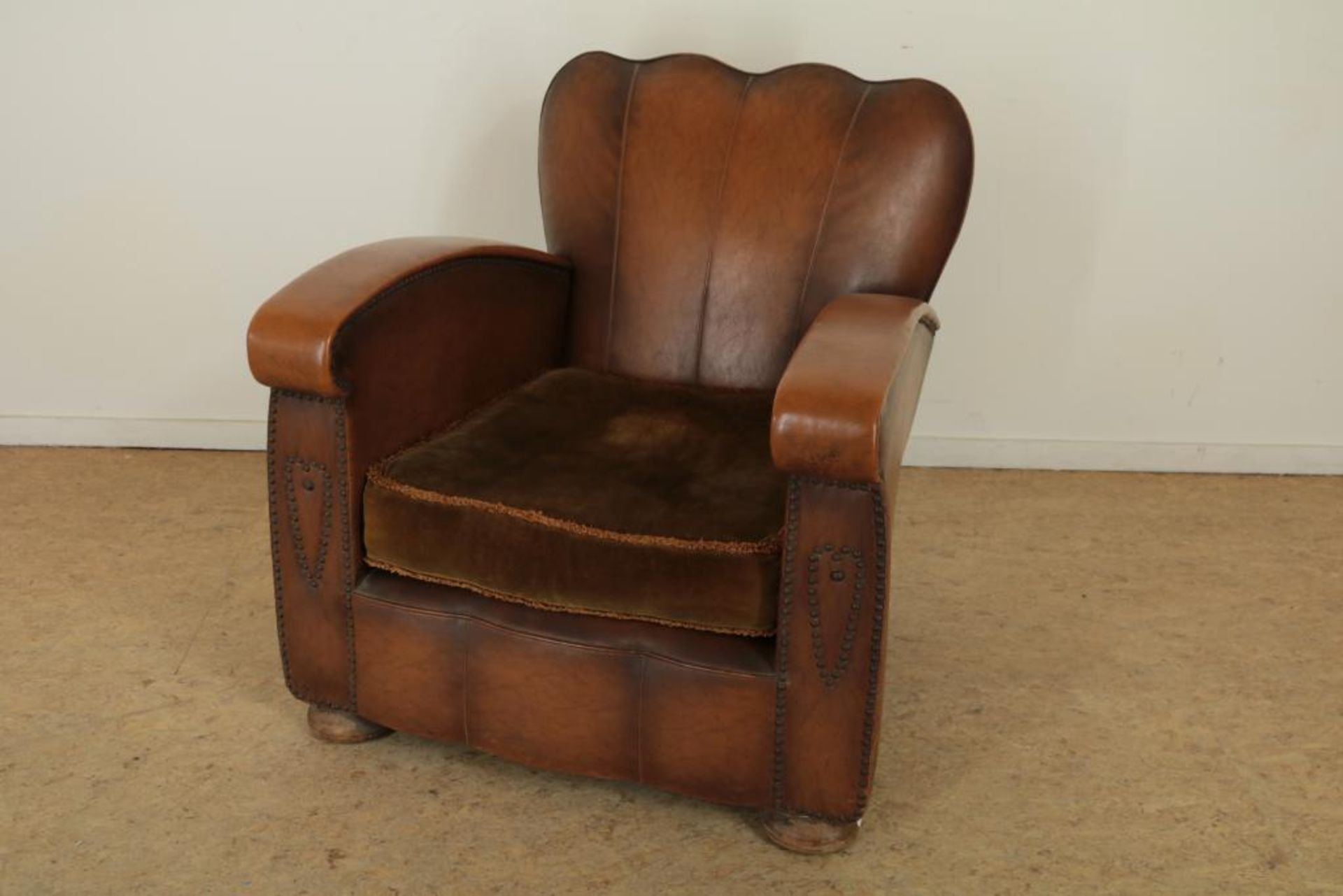 Bruinlederen Art Deco dames fauteuil met groen velourse kussen.