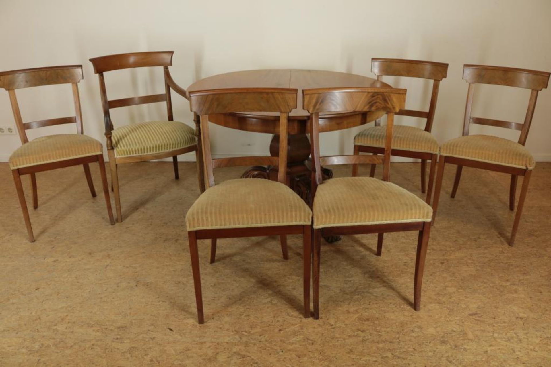 Serie van 6 mahonie stoelen (een afwijkend) en een mahonie coulissentafel op kolompoot uitlopend