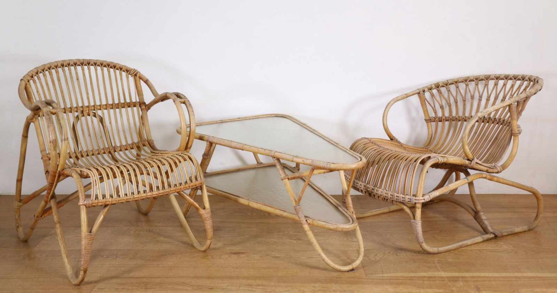 Twee rotan fauteuils, gemerkt: Trio Noordwolde Holland,hierbij driehoekvormige rotan salontafel