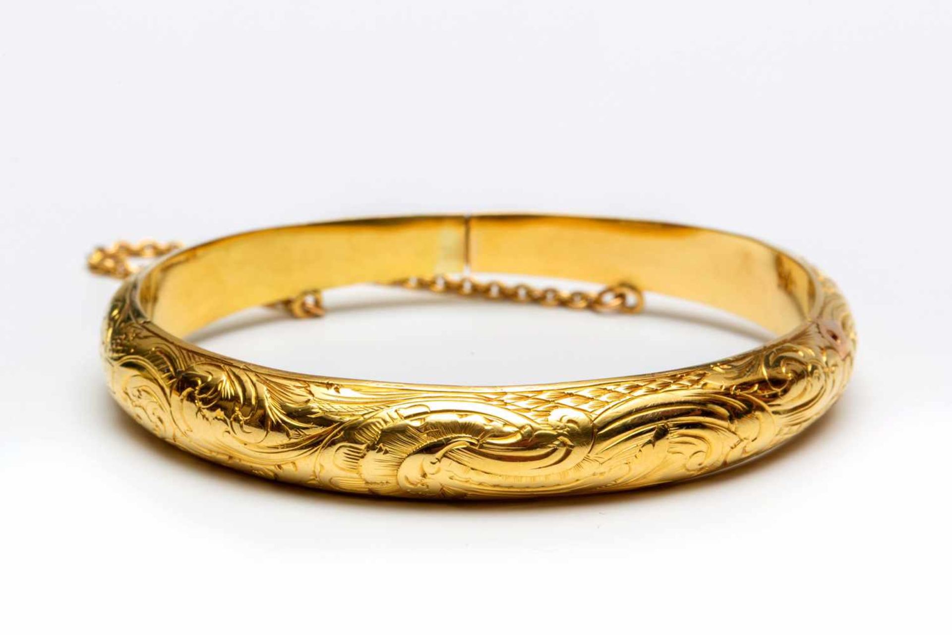 14krt. Gouden stijve armband met florale motieven versierd. Met dubbel scharnierpunt., netto 13,2