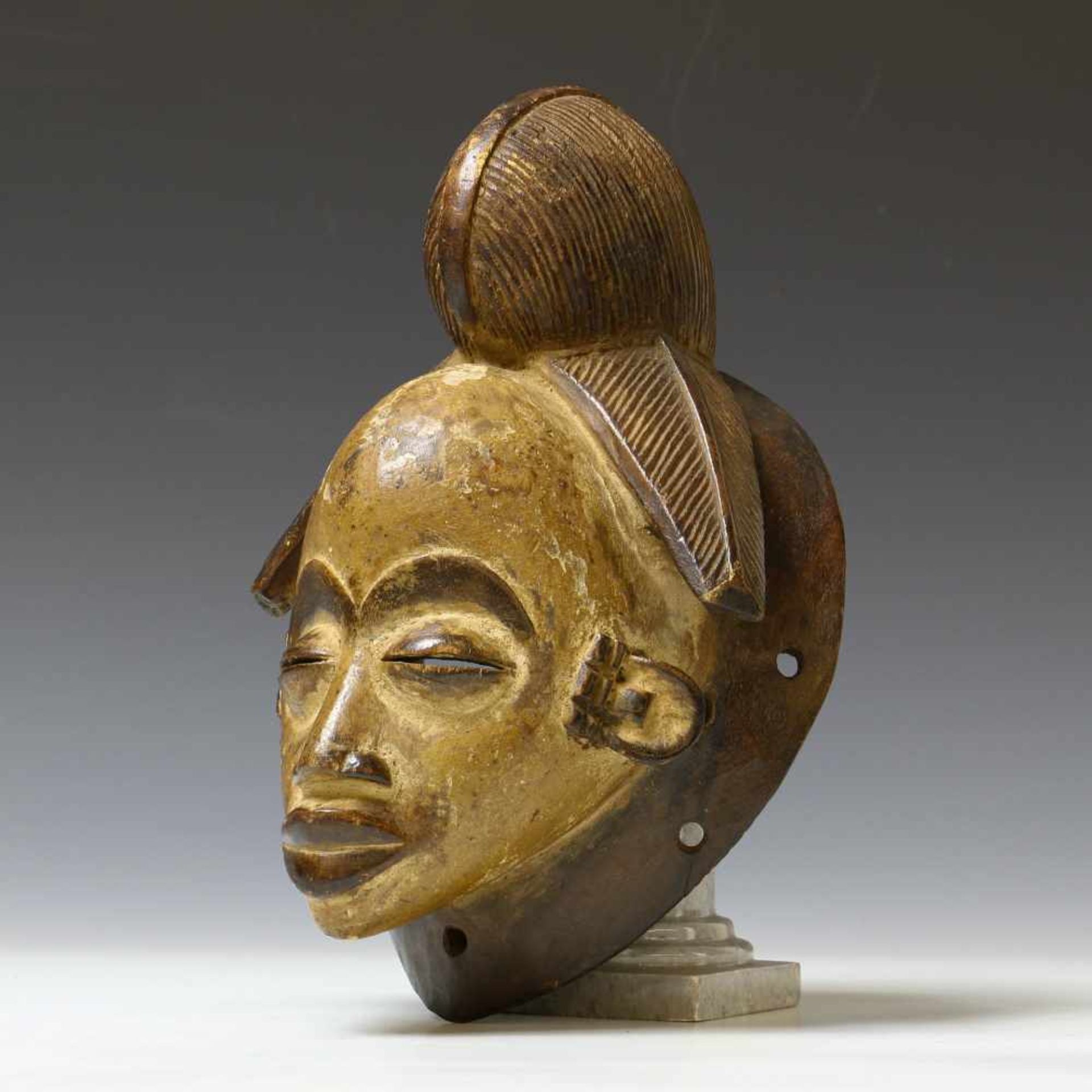 Gabon, Punu, face mask, ca. 1950with fine carved hair and brown, black and white pigments. Private