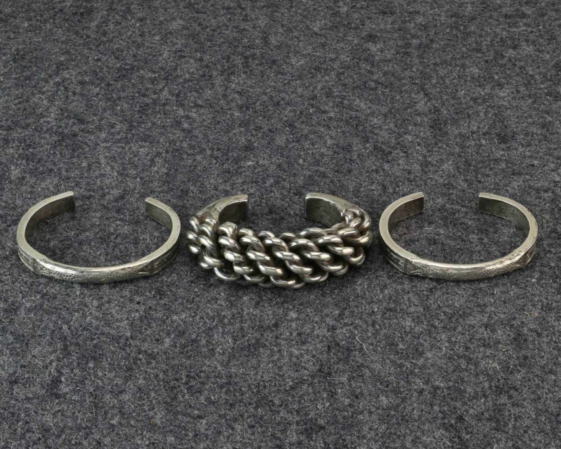 Golden Triangle, silver bracelet and a pair of solid bracelets;the twisted bracelet is worn in