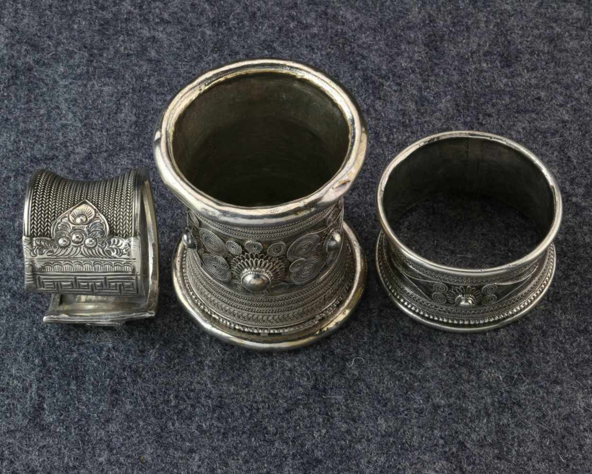Golden Triangle, Myanmar, three silver bracelets;the tubular ones are adorned with floral and