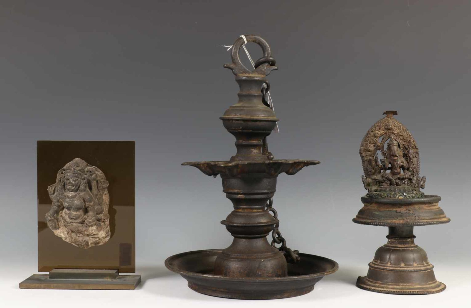 Indonesie, vulkaan stenen ornament en India, twee bronzen olielampeneen met Ganesha versierd,
