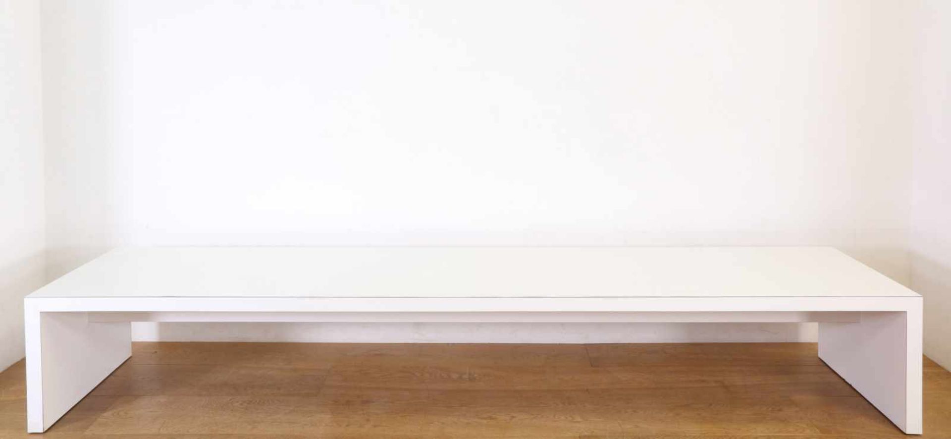 Langwerpige houten salontafelmet wit formica toplaag (besch. aan poot), 228 x 60 en h. 35 cm [1]400