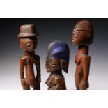Benin, a pair of ere ibeji, the male wearing a European hat, and Benin, Anago, a female twin figure