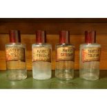 Engeland, vier bruin glazen apothekers flessen met bakelieten doppen, 19e eeuw.