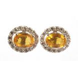 White gold entourage ear studs, 14 krt., Set with yellow sapphire approx. 1.32 ct. And brilliant cut