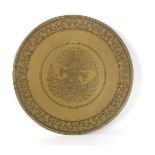 Brass wall dish with stylized decoration of peacocks in the middle and leaf decoration in the rim