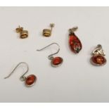 A collection of amber jewellery to include two silver and amber pendants, a pair of silver and amber