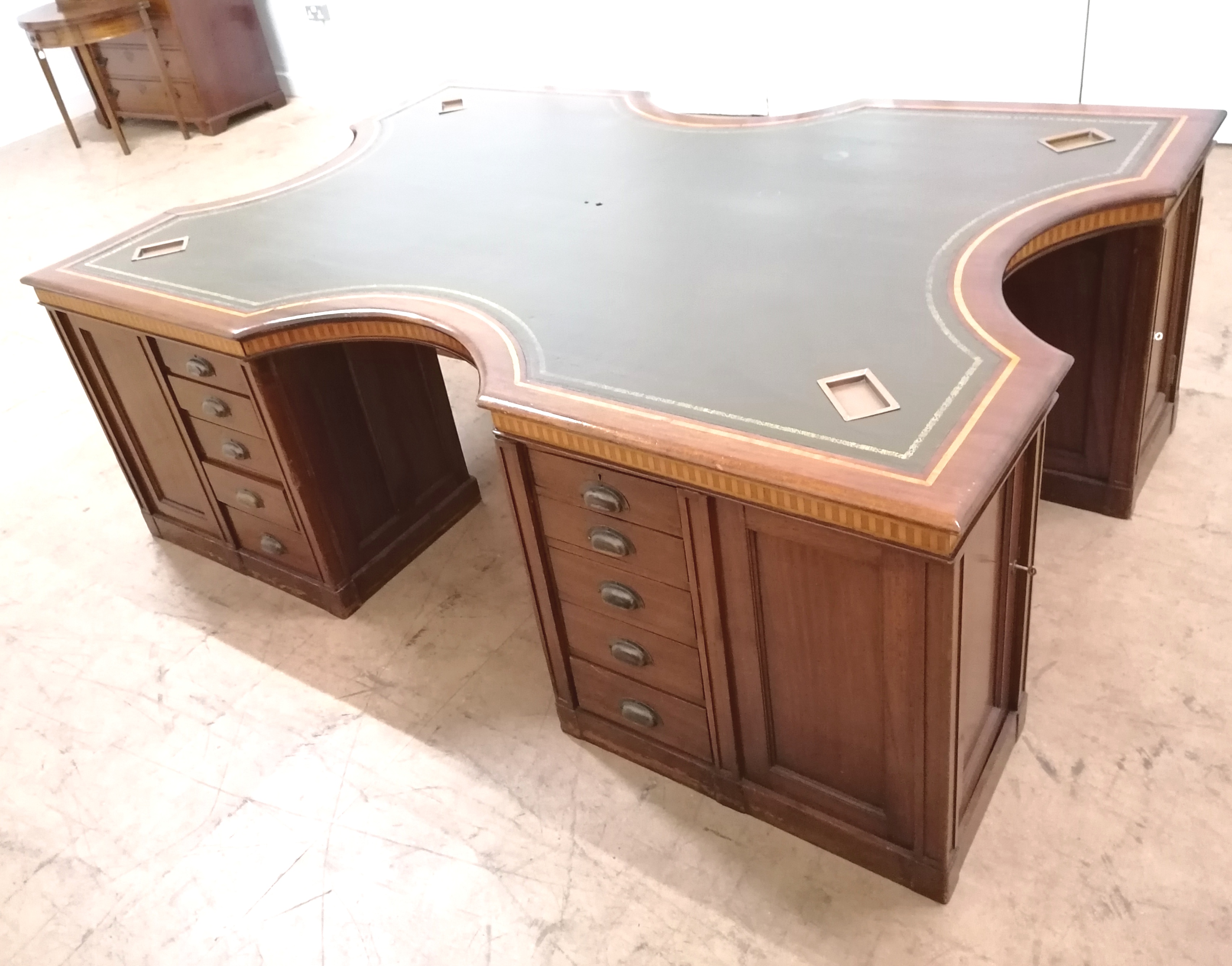A 1920/30s mahogany and inlaid partners desk of large proportions, having a shaped top with inset