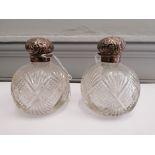 A pair of silver topped cut glass scent bottles 12cm in height