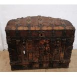 An 18th century worked leather and metal bound domed topped trunk having a hinged lid enclosing