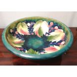 A large Moorcroft leaf and berry green glazed bowl, having impressed W. Moorcroft mark to base. 33cm