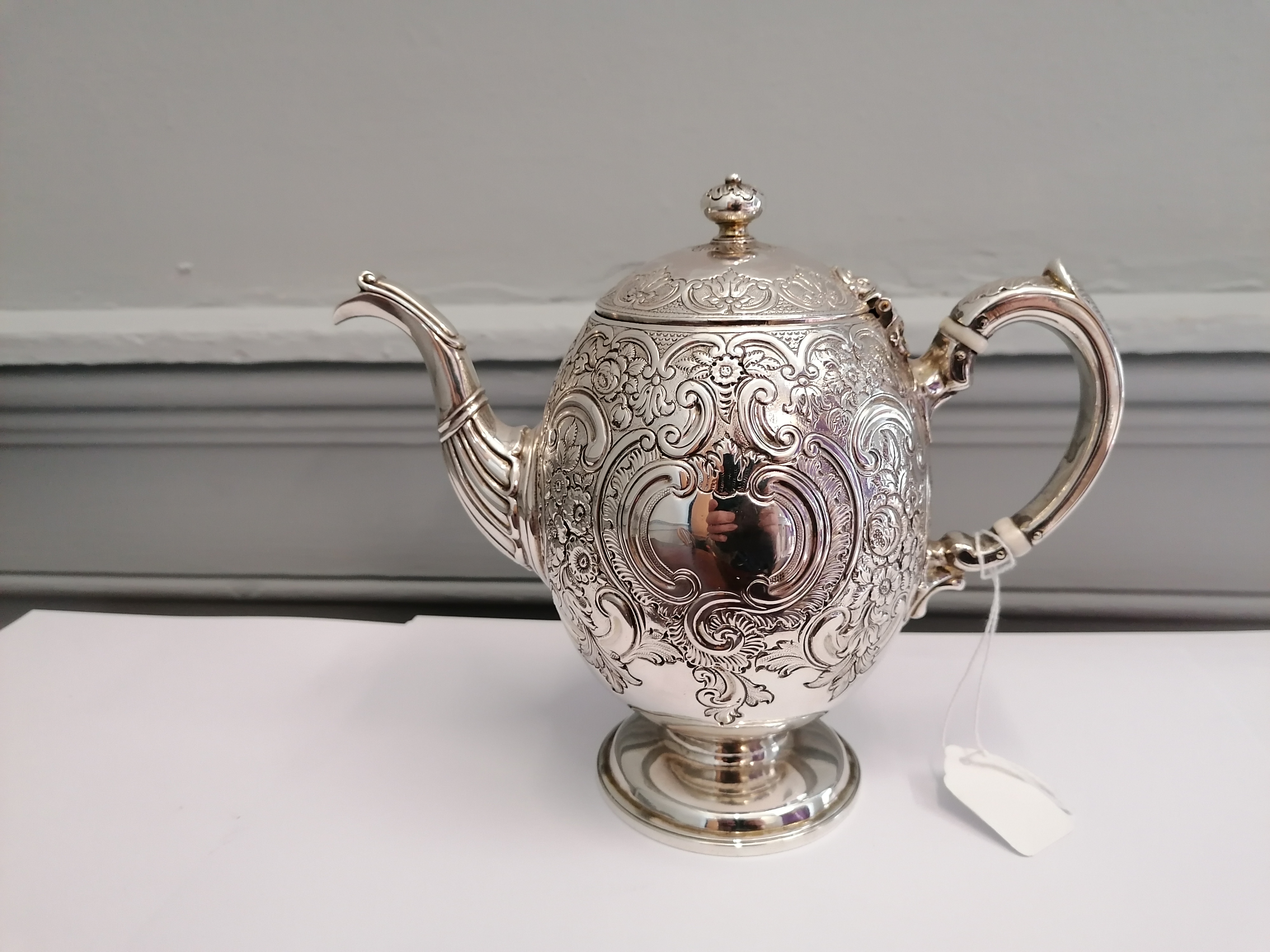 A Marshall and sons Edinburgh silver tea pot having repousse/chased c scroll and foliage design,