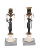 A pair of Louis XVI patinated and gilt bronze figural lustre candlesticks