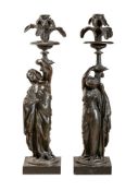 After Jean Jacques Pradier (French, 1790 - 1852), a pair of patinated bronze figural candlesticks in