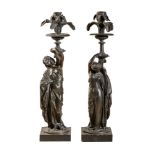 After Jean Jacques Pradier (French, 1790 - 1852), a pair of patinated bronze figural candlesticks in