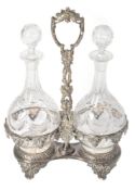 A pair of Victorian cut and etched glass decanters presented in a silver plated stand