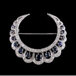 A sapphire and diamond crescent brooch