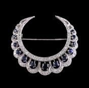 A sapphire and diamond crescent brooch