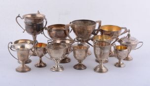 Twelve silver or silver coloured trophy cups