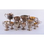 Twelve silver or silver coloured trophy cups