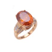 An orange stone and diamond ring