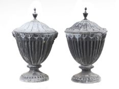 A pair of cast lead garden urns in George III Adam taste