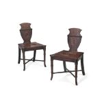 A pair of late George III mahogany hall chairs, circa 1800